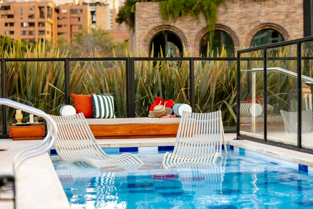 Rooftop pool with lounge chairs and views over El Poblado at Loma Verde, Medellín
