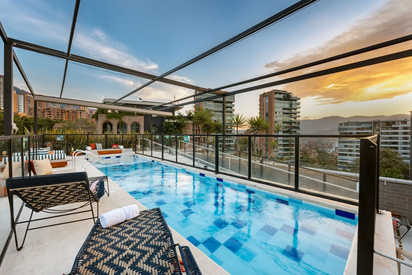 The rooftop lap pool at sunset under its glass canopy at Loma Verde, Medellín