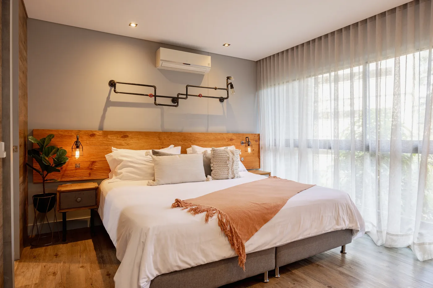 Bedroom with garden-view windows in a one-bedroom furnished apartment at Loma Verde, Medellín
