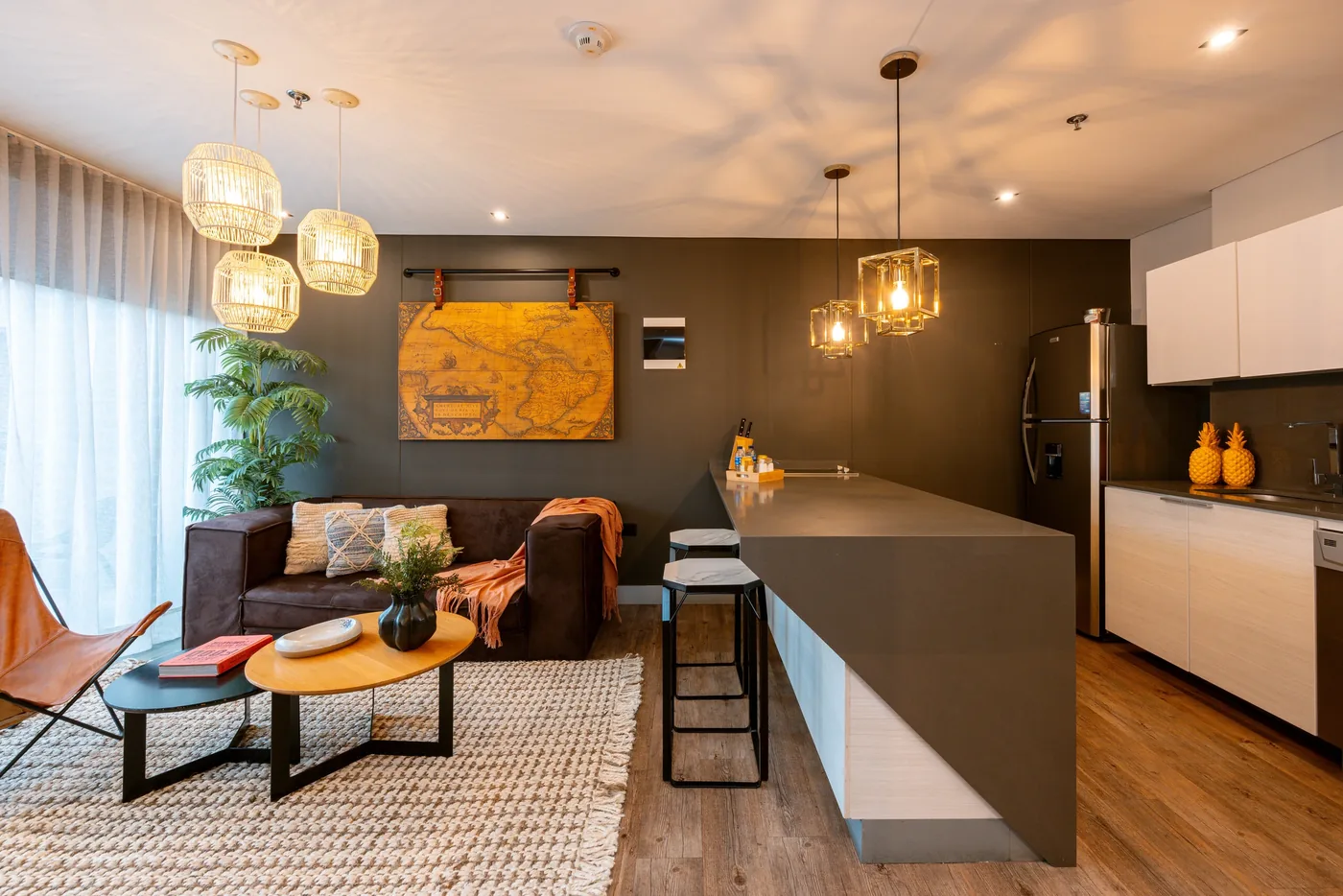 Living room opening onto the kitchen island in a one-bedroom furnished apartment at Loma Verde, Medellín