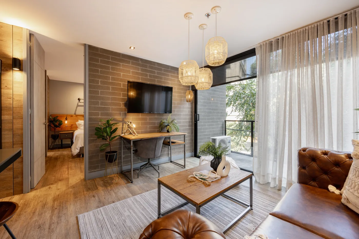 Living room with TV and desk in a one-bedroom furnished apartment at Loma Verde, Medellín