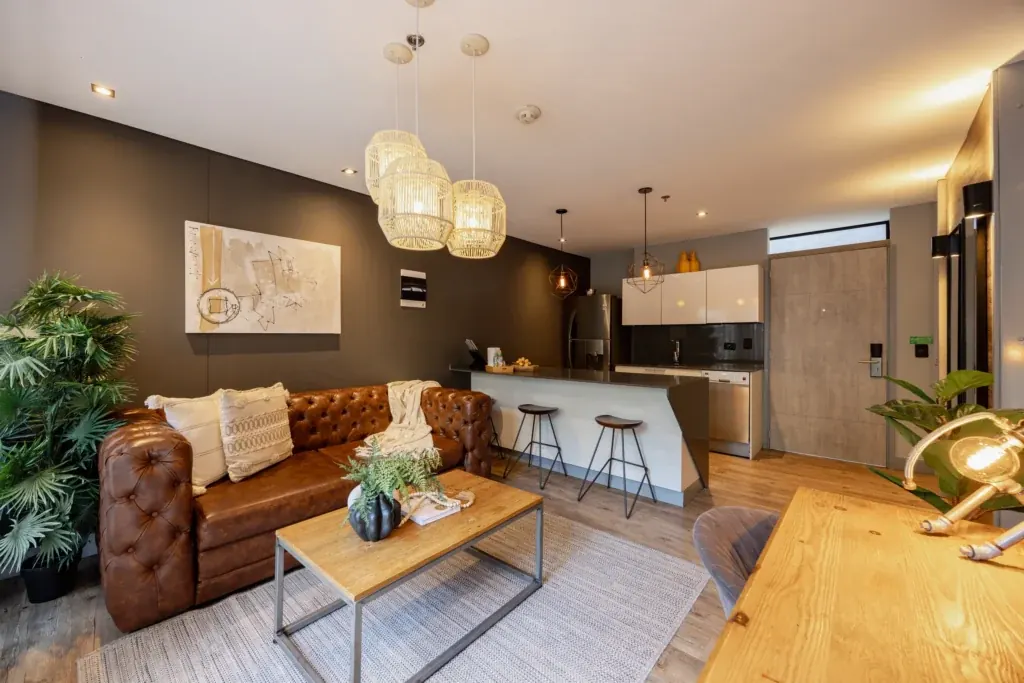 Open-plan living room and fully equipped kitchen in a furnished apartment at Loma Verde, Medellín