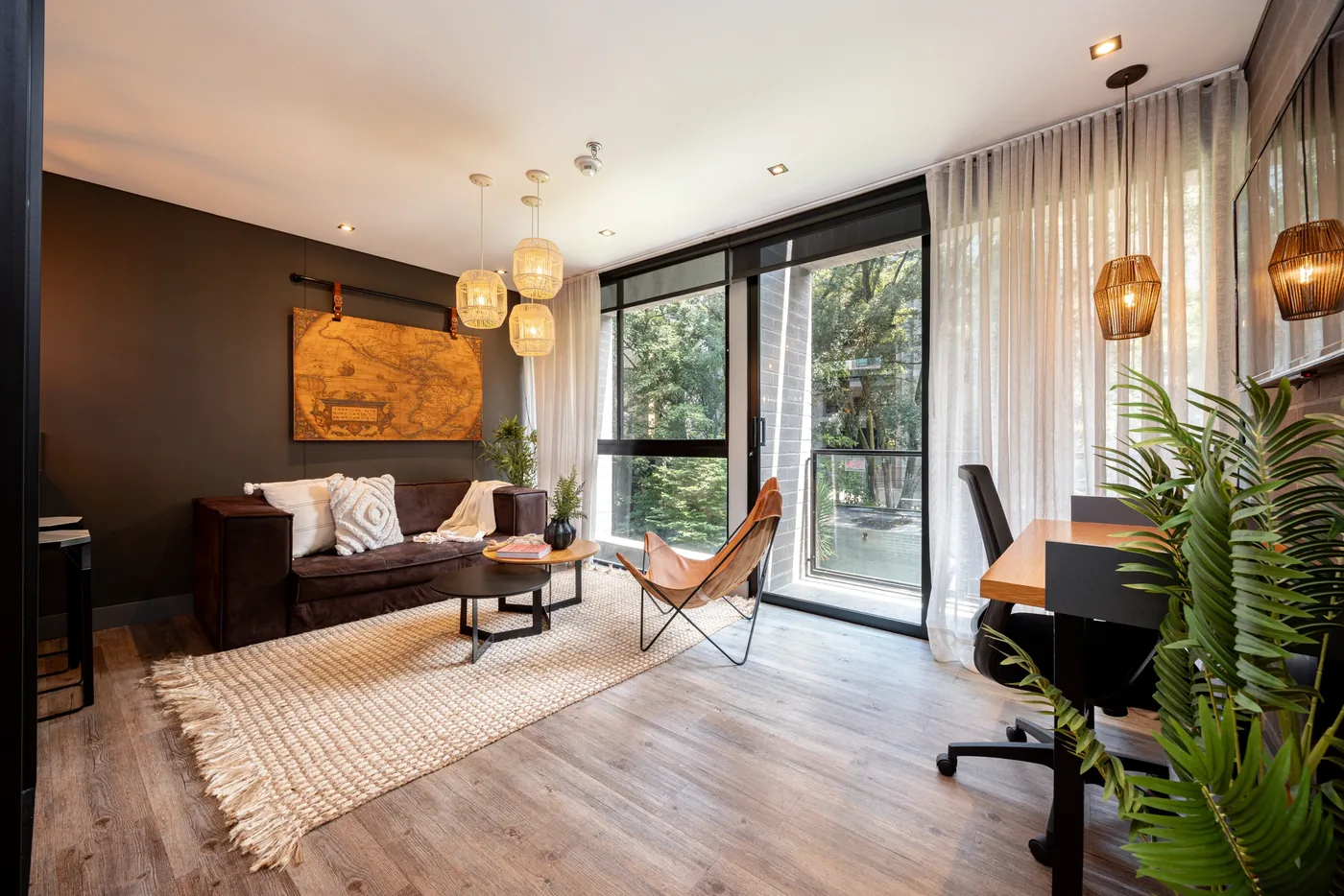 Living room with sofa and workspace in a one-bedroom furnished apartment at Loma Verde, Medellín