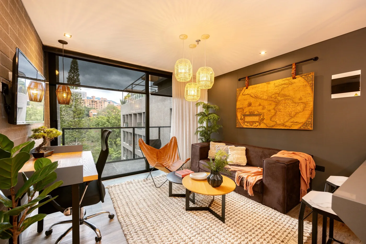 Living room with desk and balcony doors in a one-bedroom furnished apartment at Loma Verde, Medellín