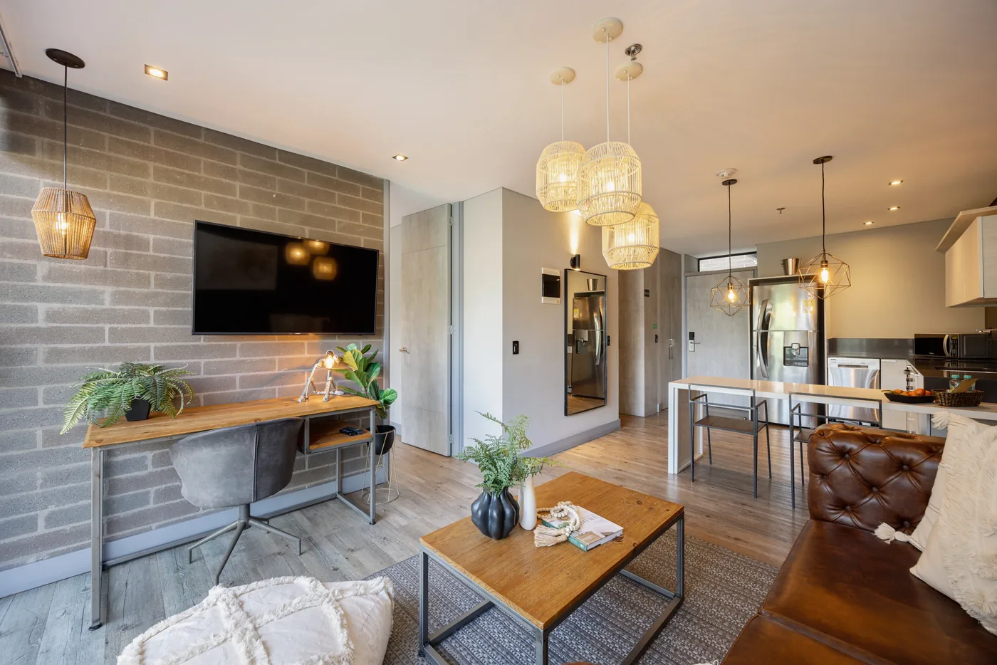 Living and dining area with TV wall in a two-bedroom furnished apartment at Loma Verde, Medellín
