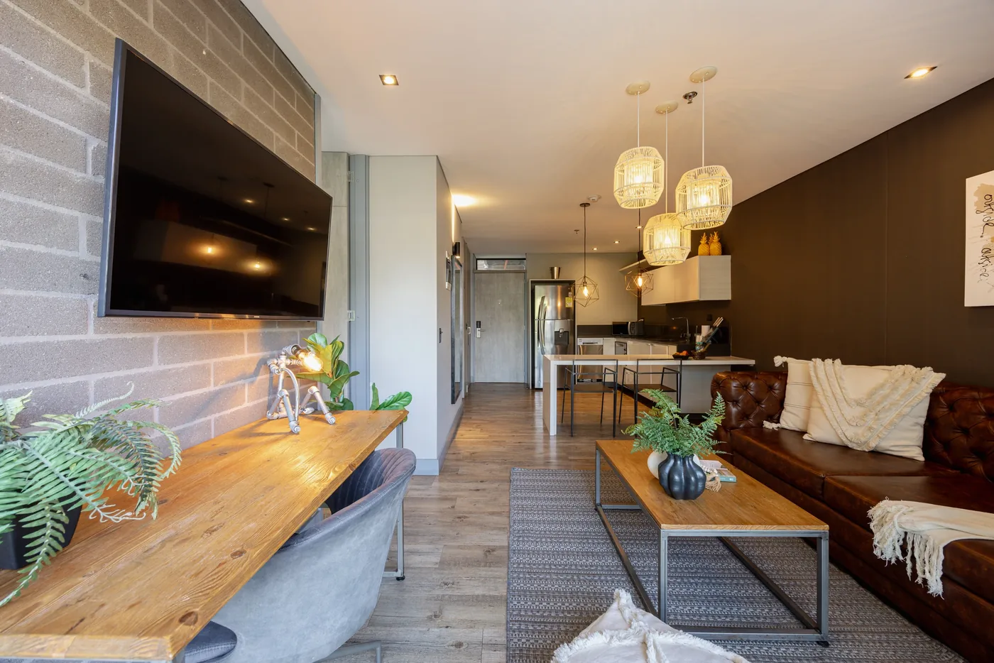 Long living room with desk wall in a two-bedroom furnished apartment at Loma Verde, Medellín