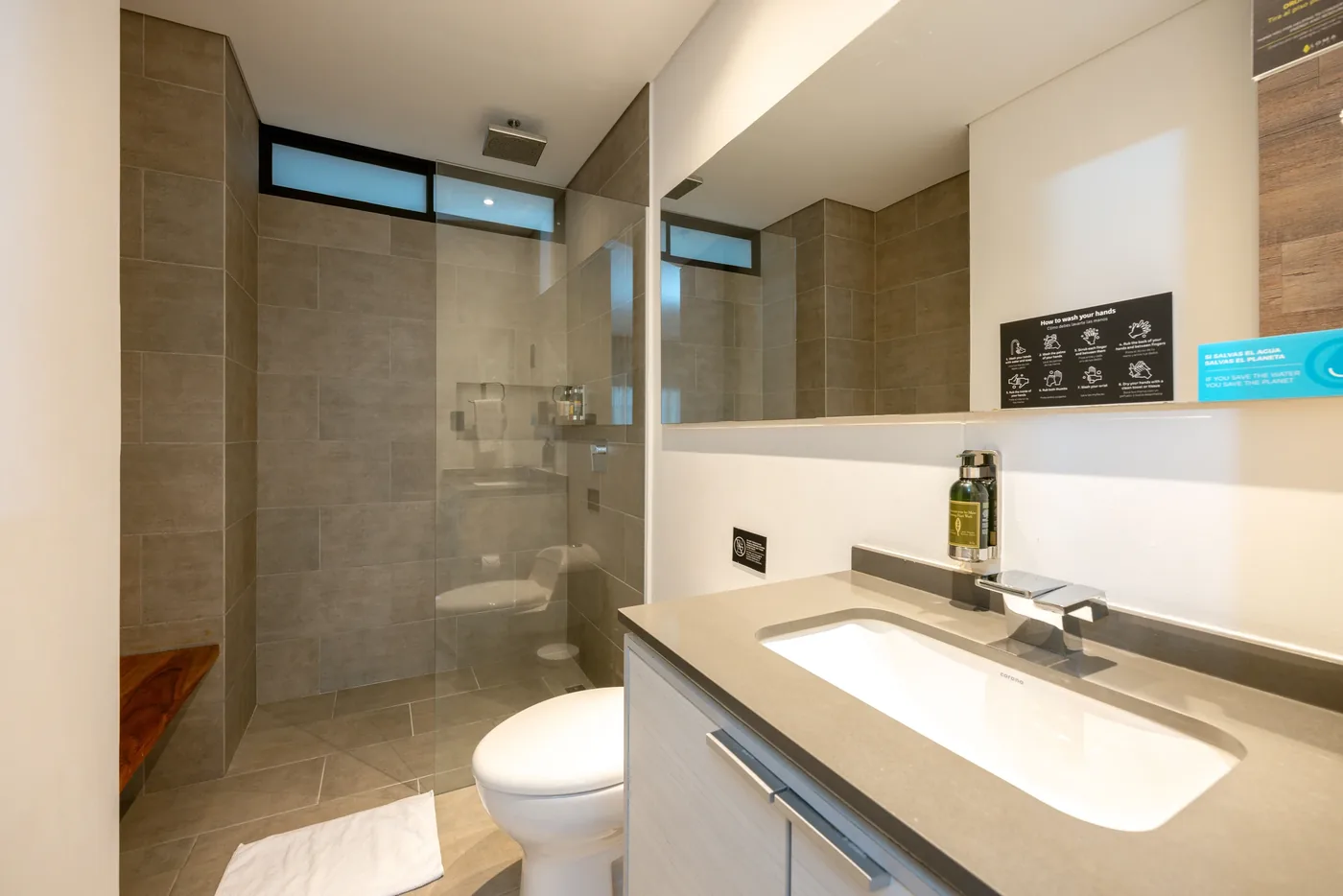 Bathroom with glass shower in a one-bedroom furnished apartment at Loma Verde, Medellín